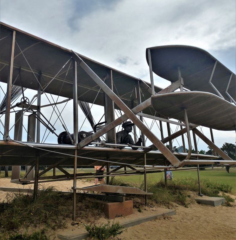 This monument at the Wright Brothers Memorial shows the elevator in the front and depicts Wilber Wright, laying down at the controls.