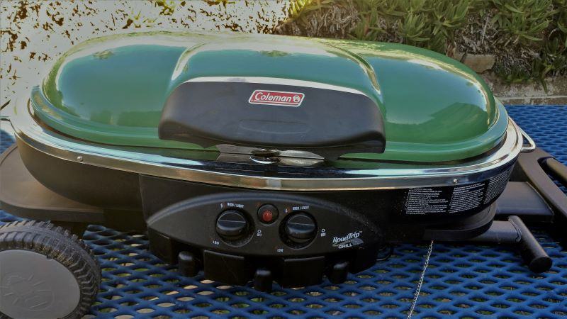 Our previous Coleman two-burner grill has a built-in grill stand and tray tables.