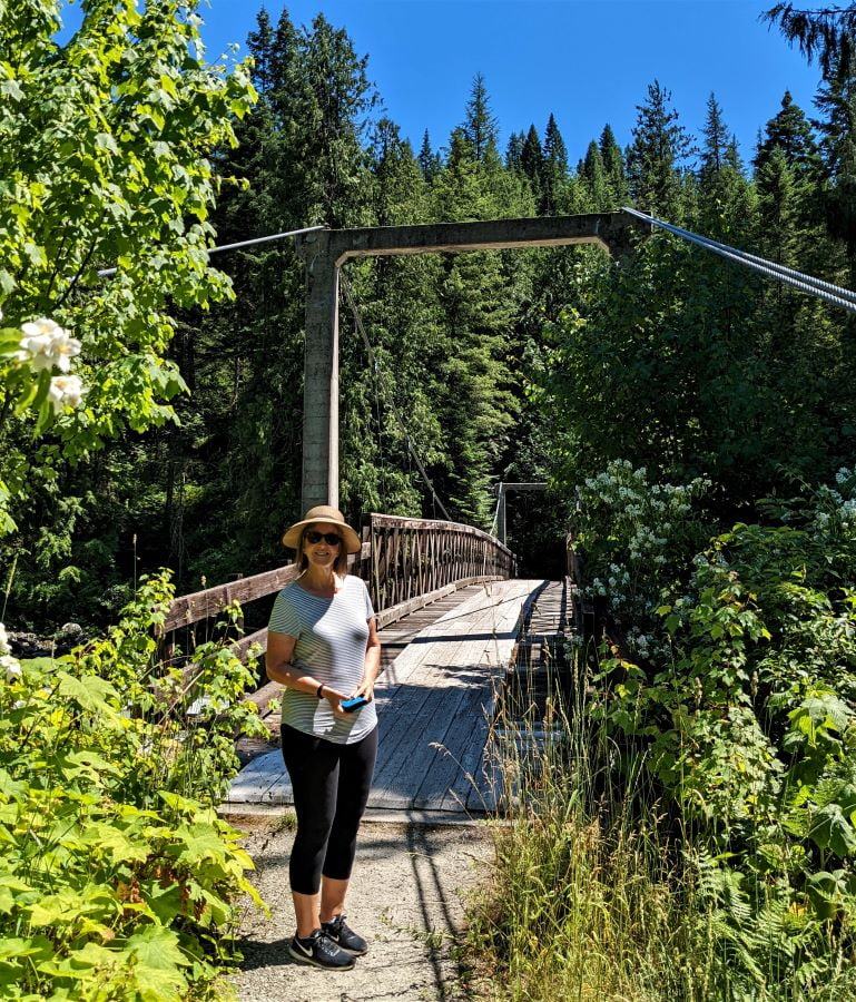 Tami standing next to the suspension bridge crossing the Lochsa River.