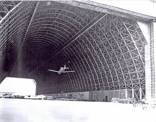 Airplane flying through hanger two at Tillamook Naval Air Station.