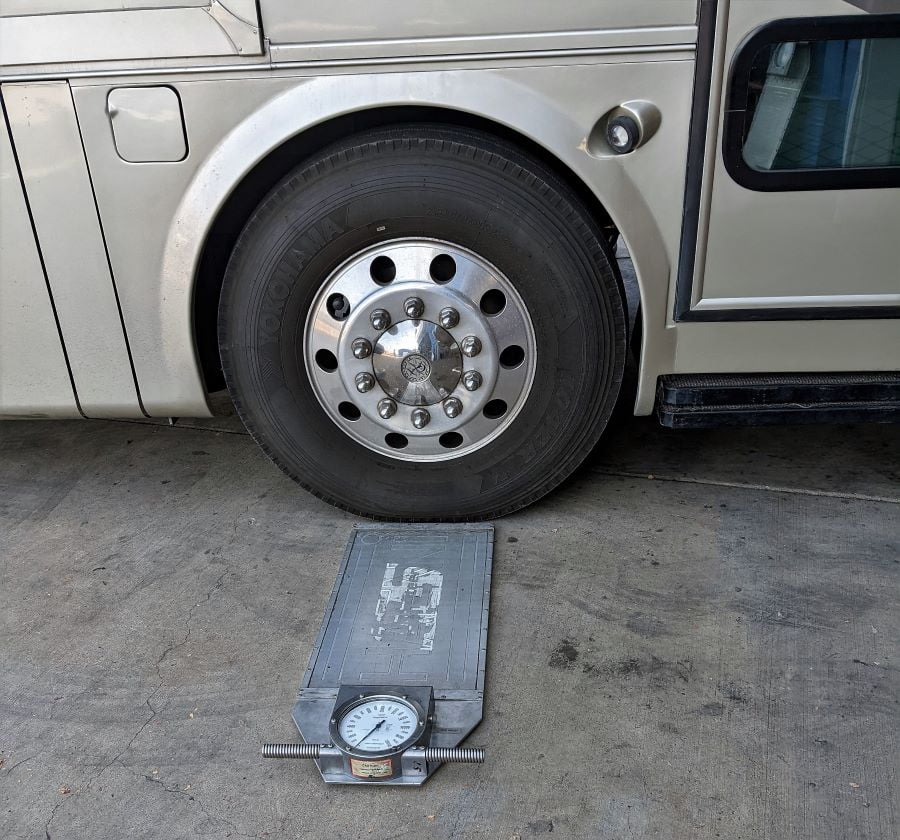 One of these scales is placed under each wheel to measure the weight on each tire independently.