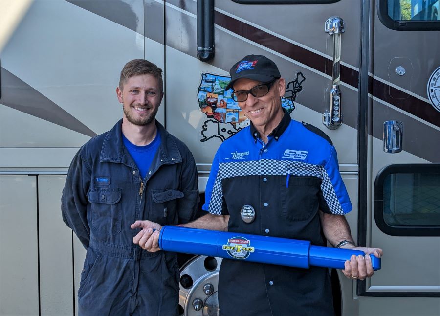 Robert holding a Steering stabilizer and his son Tommy. They made a great team. Can you tell who spent most of the time under my RV? Robert is holding a  Safe-T-Plus steering stabilizer like the one we installed on our RV. 