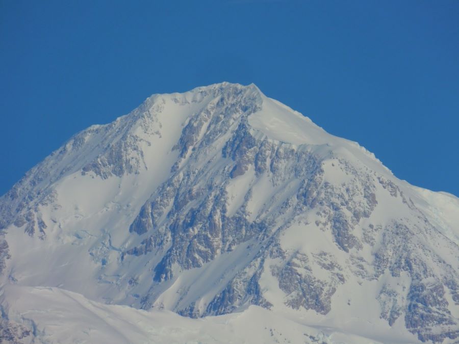 This photo was at maximum zoom on my camera and also cropped in my computer to get even closer to the top of the south peak of Denali. To get a picture better than this you would need a lens about the length of my leg and a tripod to hold it up. as for me I set the camera on a bench.