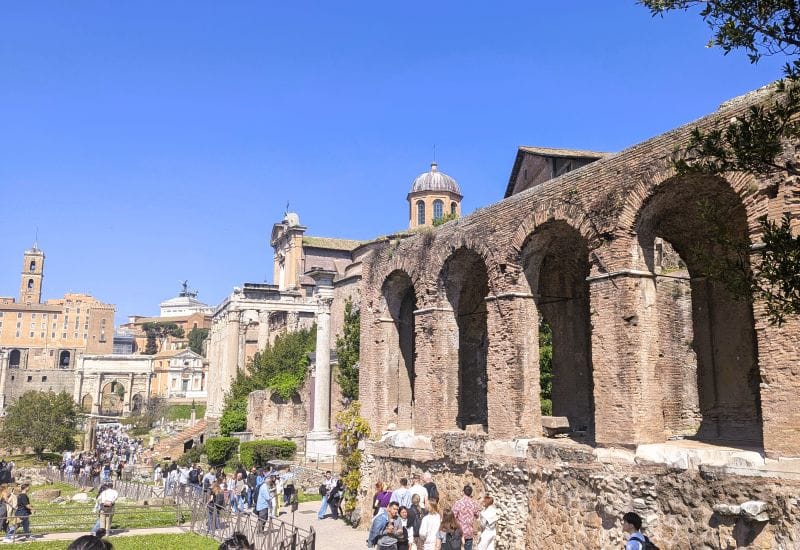 Portico Medievale (medieval) is at the right of this picture. Above the arches is the dome of The Temple of Antoninus and Faustina.To the left along the skyline is the Monument Victor Emmanual followed by the The Torre (tower) della Patarina and Tabularum. Photos are from the FoxRVTravel article “The Roman Forum.”