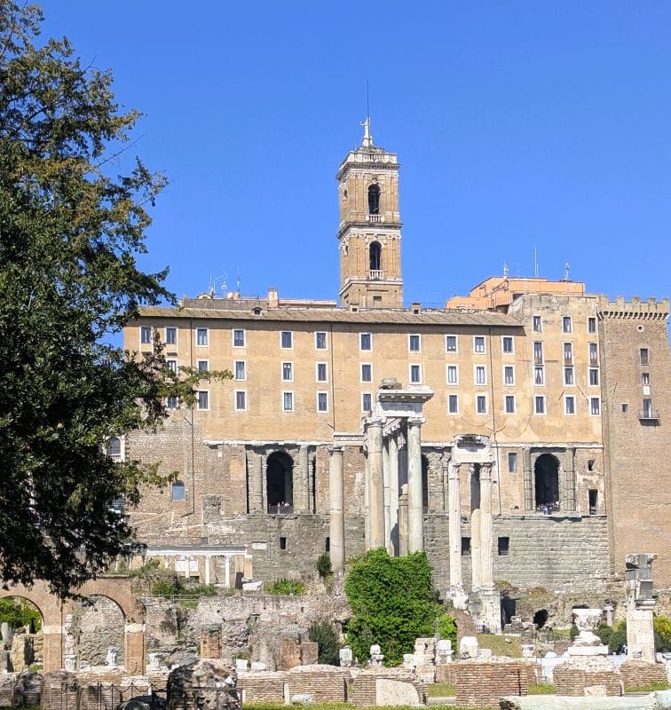 The Torre (tower) della Patarina as seen from the forum. Below the tower is the Tabularum which was the records keeping site for the Roman Empire. In front of the Tabularium are the behind the corner columns of the Temple of Vespasian and Titus. Photos are from the FoxRVTravel article “The Roman Forum.”