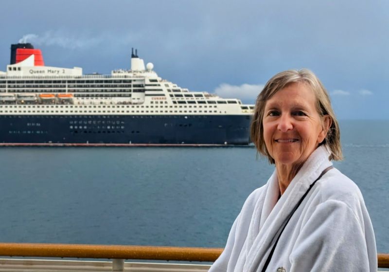Tami is standing on our balcony, still wearing her robe. In the background the Queen Mary 2 is passing while heading north in the Coral Sea. We were heading south towards Sidney.