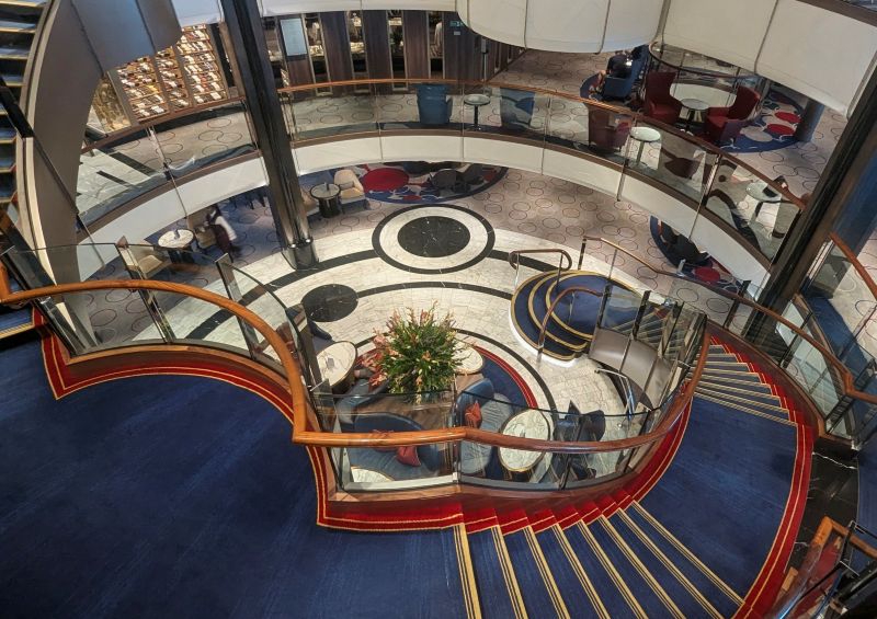 Down the Queen Anne's grand staircase with landings on three decks to the Grand Lobby.