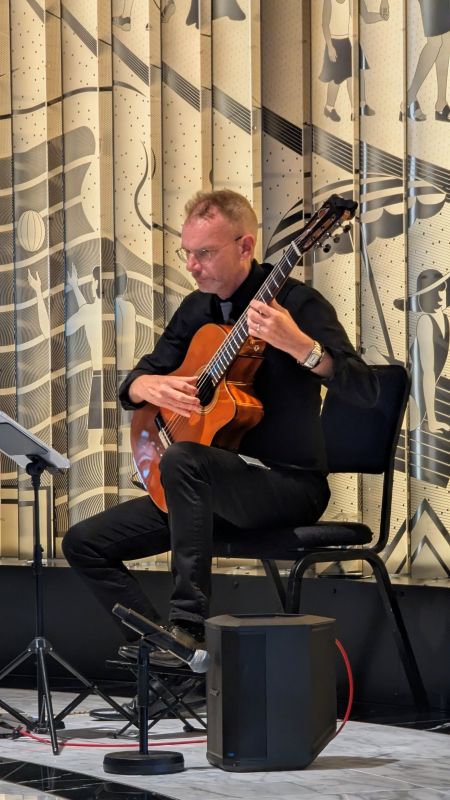 Andrew Scott plays his classical guitar daily in one of the mid-ship venues.  He for some reason hasn't rotated and has been with us for our entire journey. 