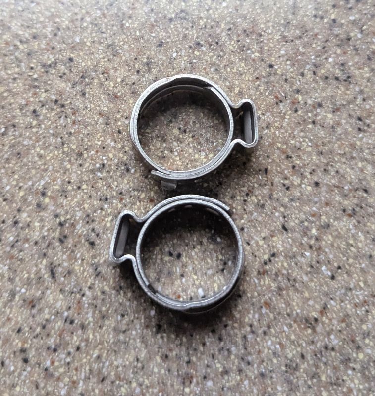 This is a closeup photo of two unused PEX B clamp fittings. If you have these stainless steel fittings on a hose your water system is a time bomb.