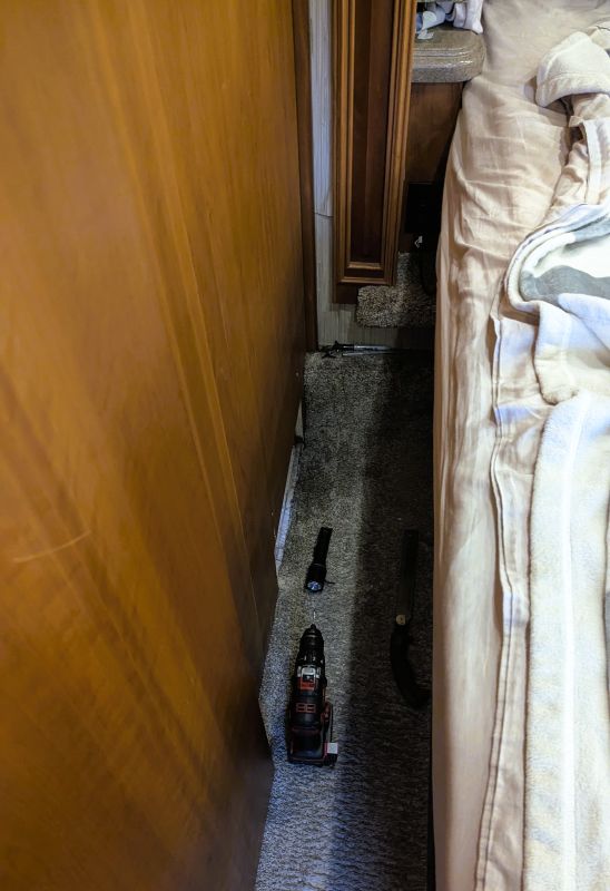 The space between our bed and the wall. Next to the flashlight there is a small heat duct that heats our bedroom.